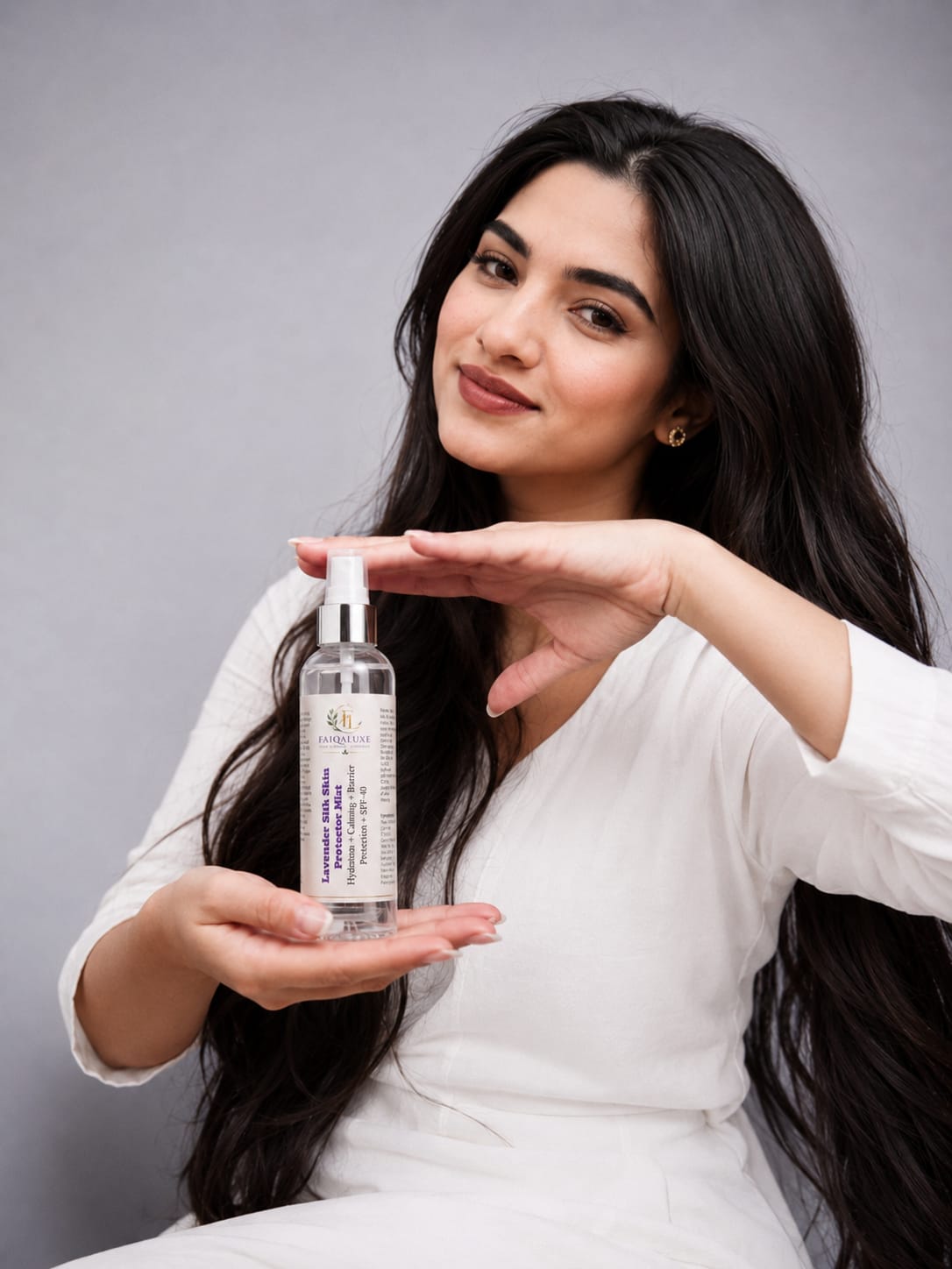 Elegant female skincare model holding Lavender Silk Skin Protector Mist by Faiqaluxe with soft glowing skin, luxury lavender aesthetic, hydration mist effect and SPF 40 skincare protection concept